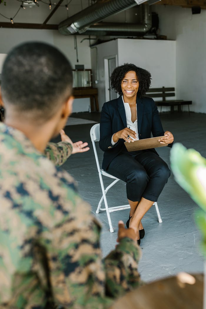 A therapist speaking with a military veteran to provide mental health support and counseling indoors.